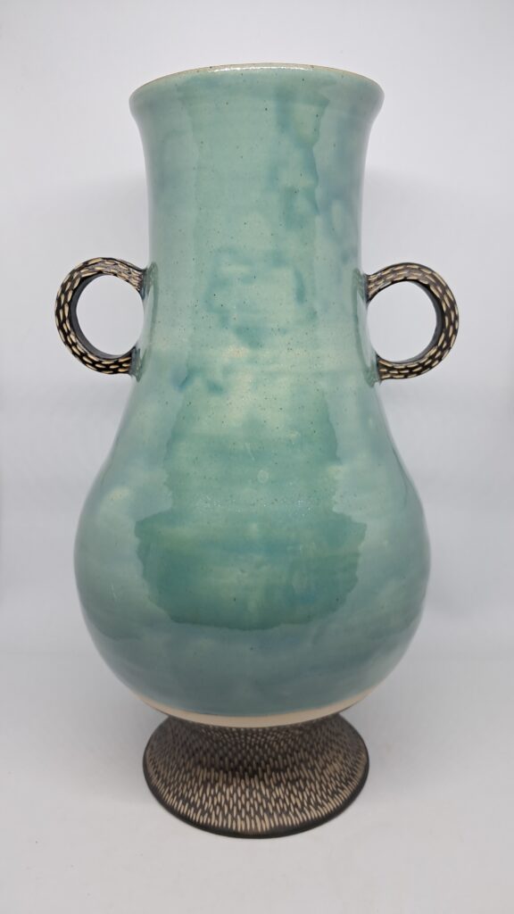 Vase style amphore à anses et ventre, bleu brillant clair. Pied et anse décorés noir sgraffité.